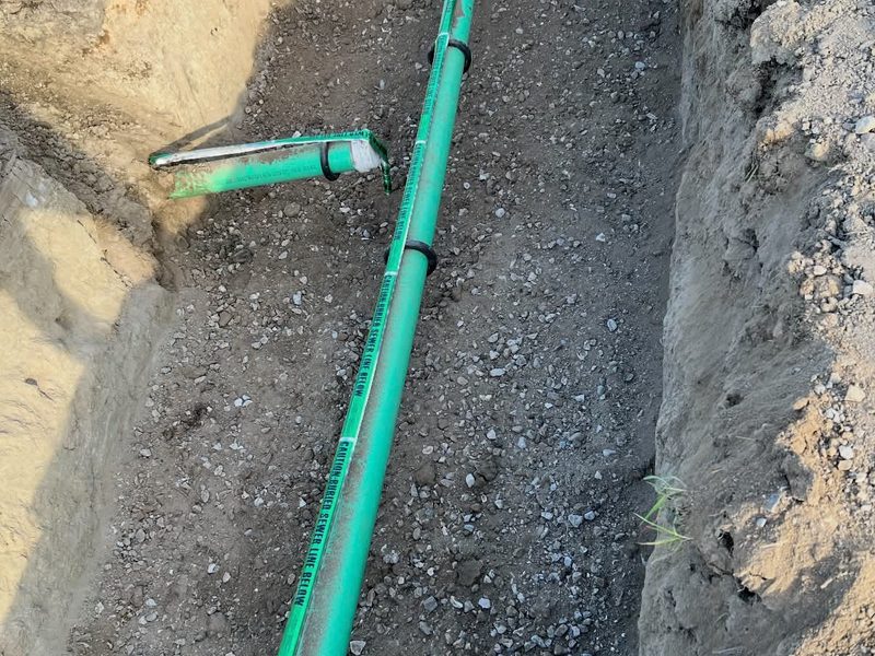 Sewer pipe laid on gravel bedding in a trench