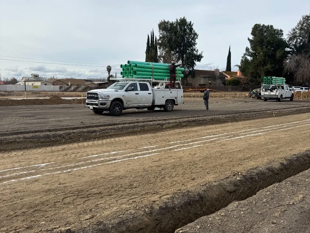 Graded site with service truck and pipe staged for installation