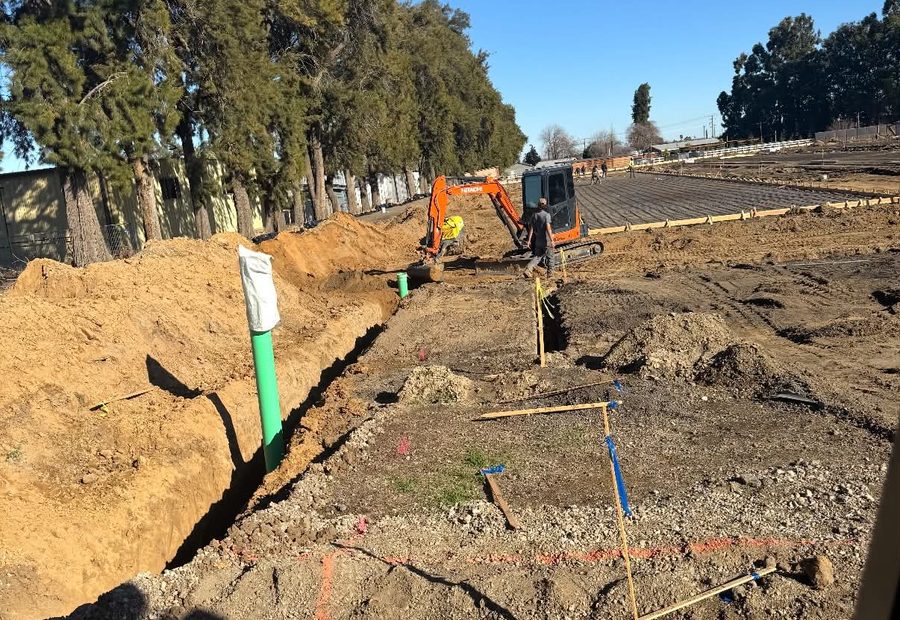 Open utility trench with pipe bedded and ready for backfill
